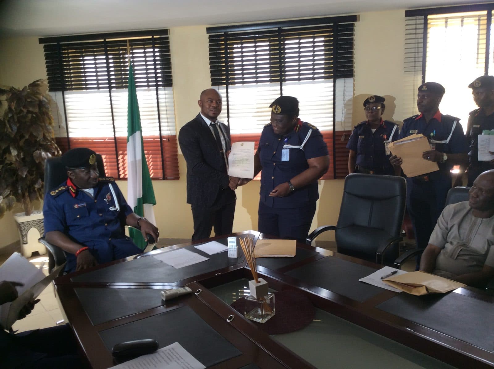 Frank Ekiudoko presenting official documents to a Nigerian security officer